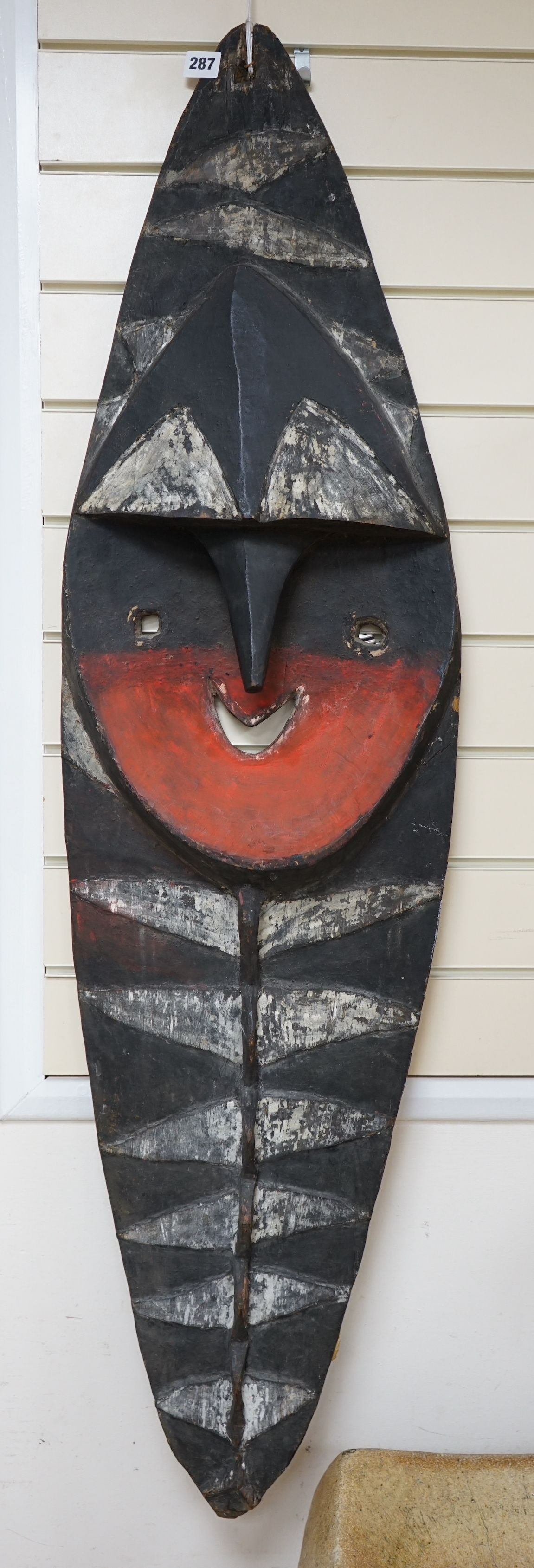 A Papua New Guinea Minja painted wood figure wall hanging in the form of a shield, 130cm tall